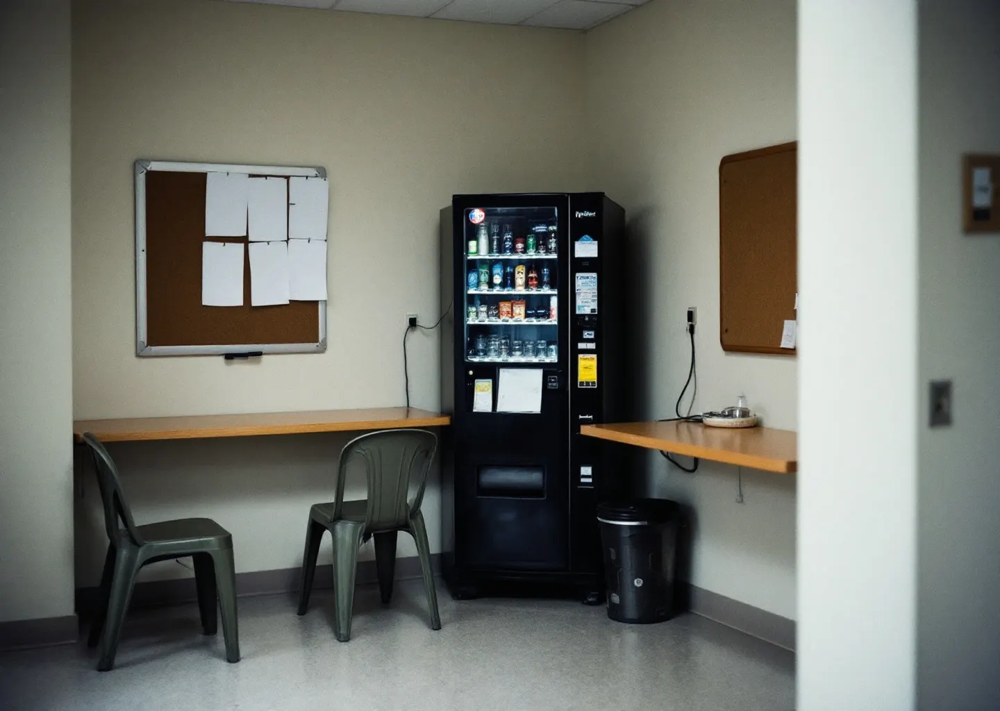 Salle de pause d'entreprise déserte, table stratifiée et chaises empilées